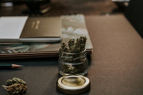 Cannabis in a glass bottle on a desk