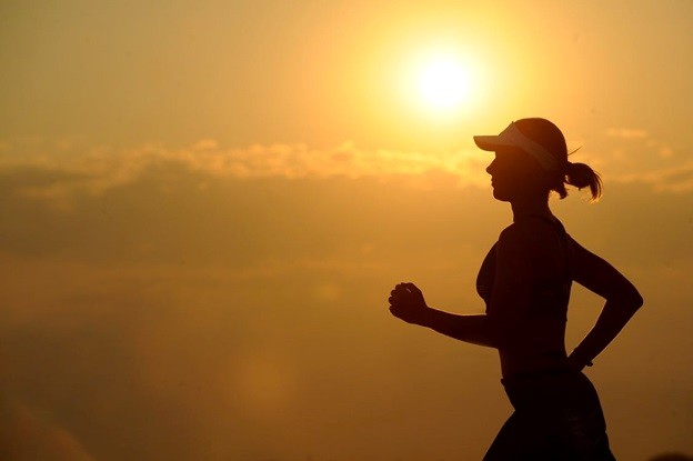 A healthy woman jogging at dawn
