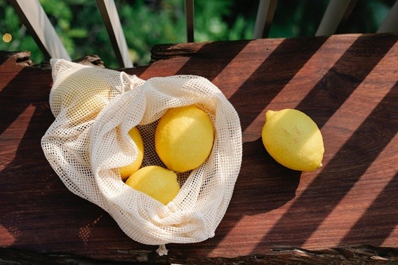 A white net bag is pictured with lemons inside it