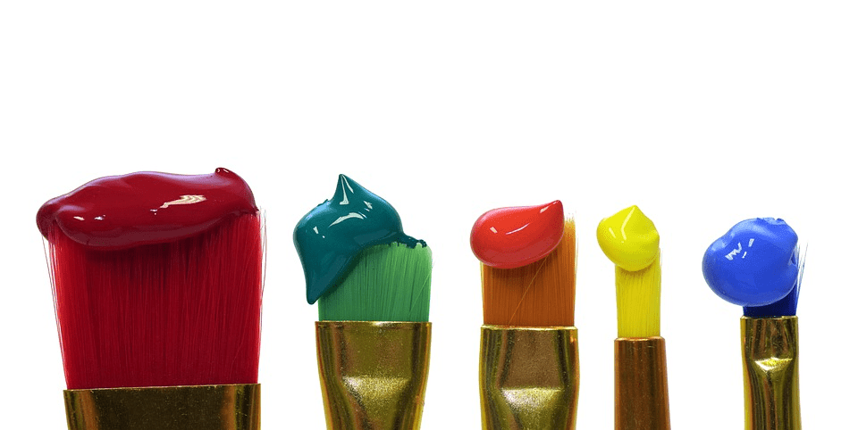 A variety of paintbrushes with paint on them.