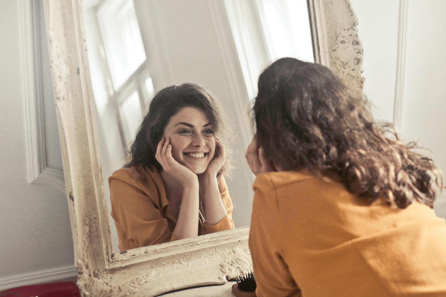 A woman smiling in the mirror.
