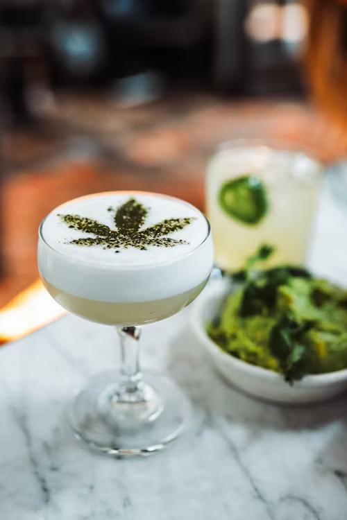 An image of a drink with cannabis plant décor  