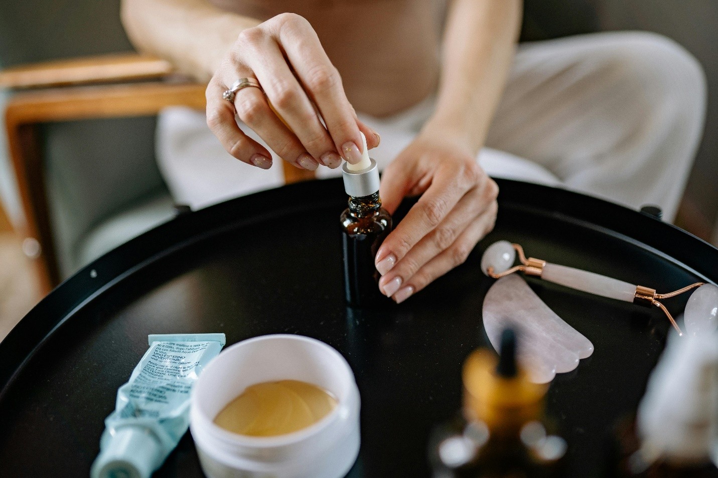 hands holding an amber glass bottle on a black table