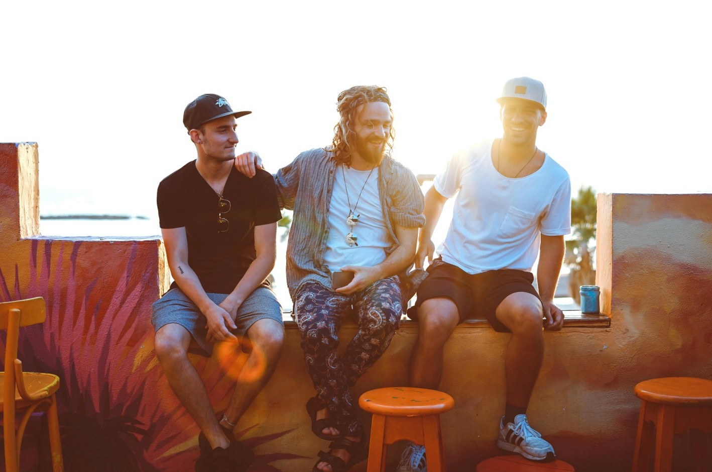 three men sitting on a veranda