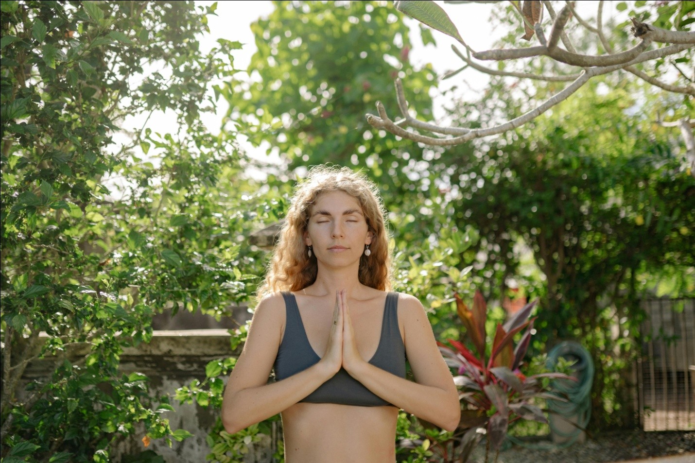 a woman meditating outdoors with eyes closed